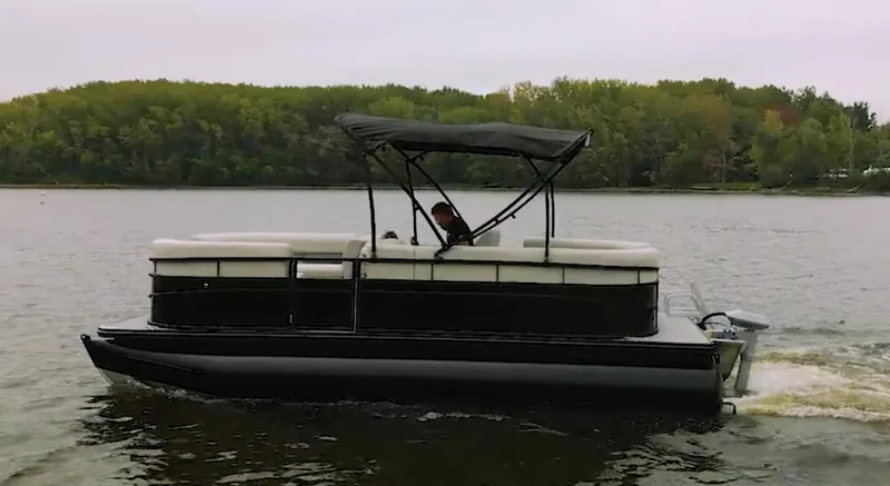 Slide: The Image of 2024 Vision Marine Technologies WX Tritoon cruising on a lake with lush green trees in the background. - 7