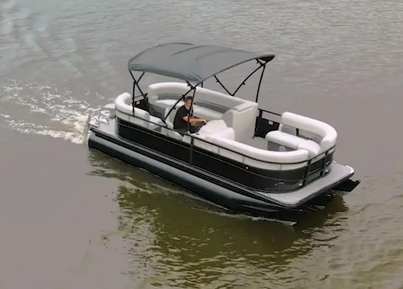 Slide: The Image of 2024 Vision Marine Technologies WX Tritoon cruising on water with canopy and seating. - 9