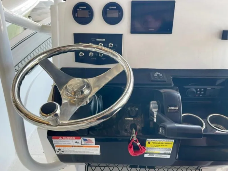 Slide: The Image of 2024 Wellcraft 202 Fisherman boat dashboard with steering wheel and Yamaha controls. - 7