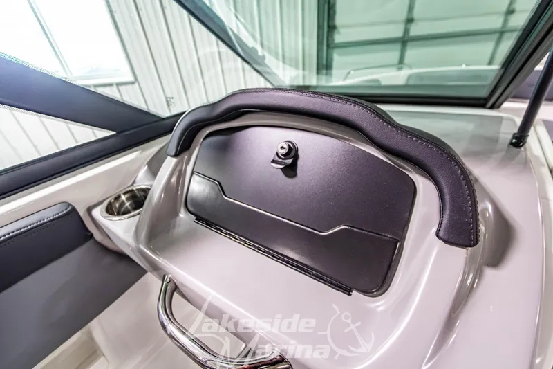 Slide: The Image of 2026 Chaparral 23 SSi boat dashboard with storage compartment and cup holder. - 22