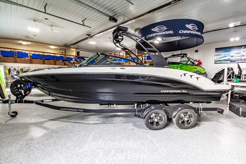 Slide: The Image of 2026 Chaparral 23 SSi boat displayed in a showroom, featuring sleek black and white design. - 7