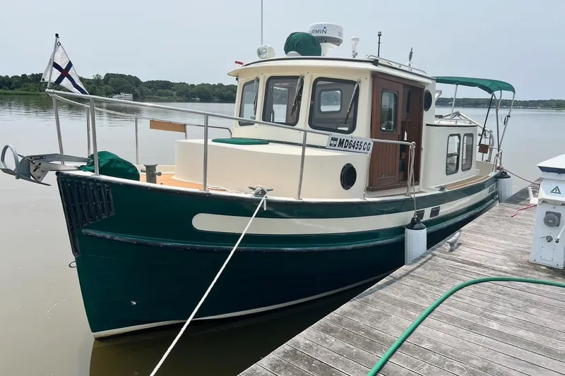The Image of 1996 Nordic Tug 26 docked, featuring green and white exterior with a classic design. - 0