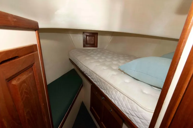 Slide: The Image of Cozy cabin interior of a 1996 Nordic Tug 26 with a comfortable bed and wooden accents. - 19