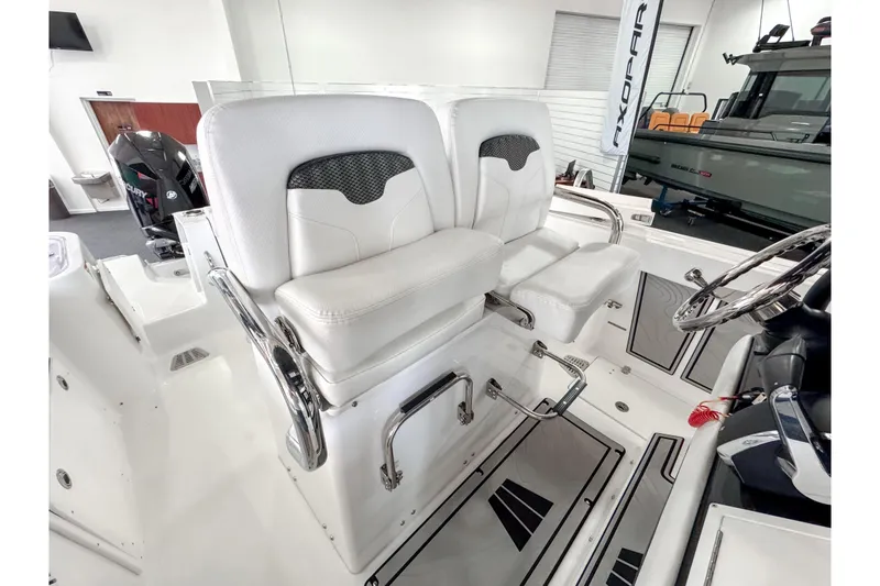 Slide: The Image of 2024 Wellcraft 263 Fisherman boat interior with dual white captain seats and steering wheel. - 21