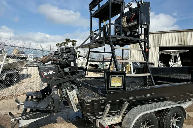 Slide: The Image of Custom 2015 2175 Bowfishing boat with elevated platform and powerful engine, parked outdoors. - 5