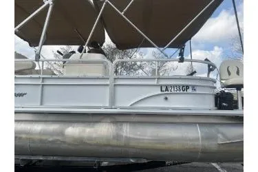 Slide: The Image of 2016 SunChaser Oasis 820 FNC pontoon boat with canopy, docked under a cloudy sky. - 2