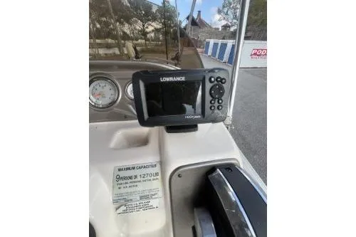 Slide: The Image of 2016 SunChaser Oasis 820 FNC boat dashboard with Lowrance fish finder and capacity label. - 8