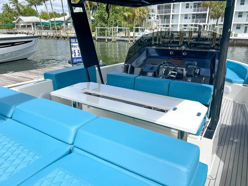 Slide: The Image of 2023 De Antonio Yachts D28 Open with blue seating and sleek design at a marina. - 15