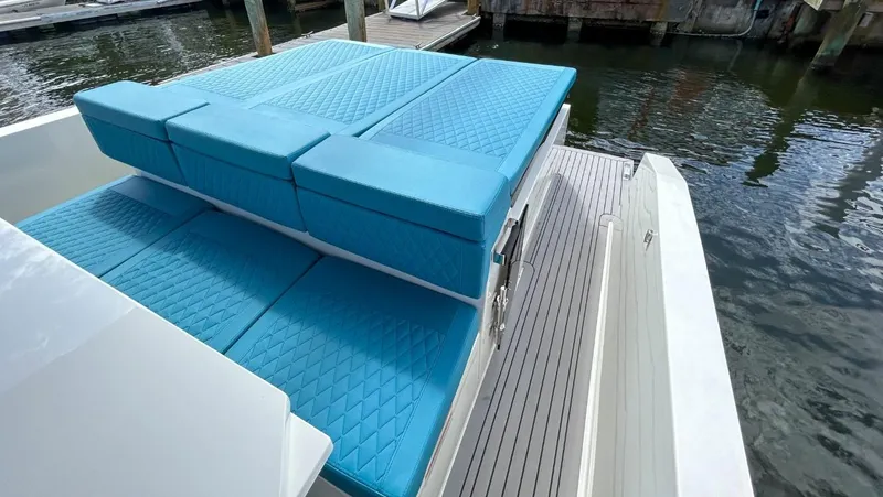 Slide: The Image of 2023 De Antonio Yachts D28 Open with blue cushioned seating, docked by the water. - 19