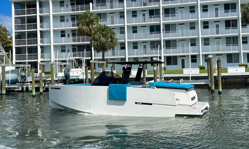 Slide: The Image of 2023 De Antonio Yachts D28 Open cruising near waterfront apartments. - 3