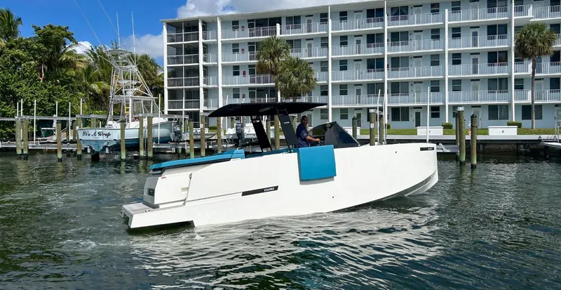 Slide: The Image of 2023 De Antonio Yachts D28 Open cruising near waterfront apartments. - 4