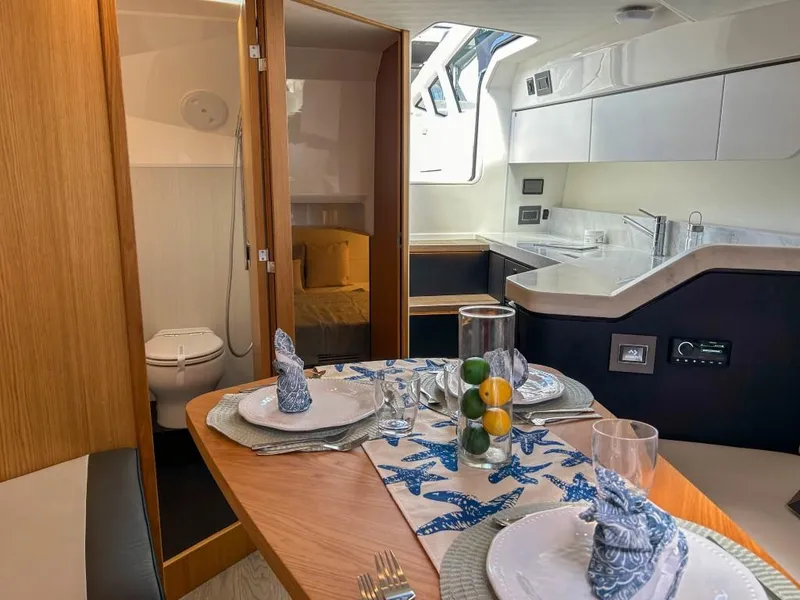 Slide: The Image of 2023 Fairline F//Line 33 Outboard interior with dining area, kitchenette, and bathroom. - 13