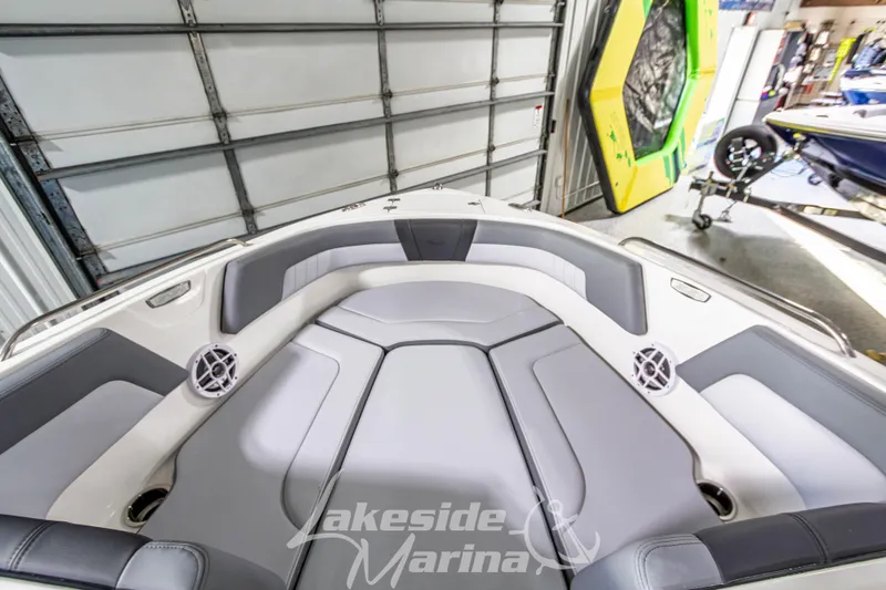 Slide: The Image of 2026 Chaparral 23 SSi boat interior with gray seating and speakers in a marina. - 24