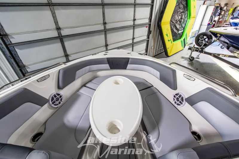 Slide: The Image of 2026 Chaparral 23 SSi boat interior with seating and table in a marina. - 25