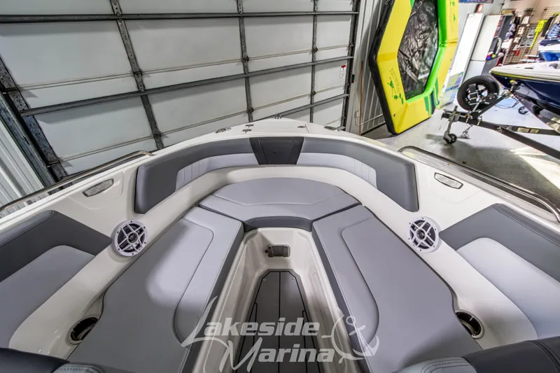 Slide: The Image of 2026 Chaparral 23 SSi boat interior with gray seating and speakers in a marina. - 26