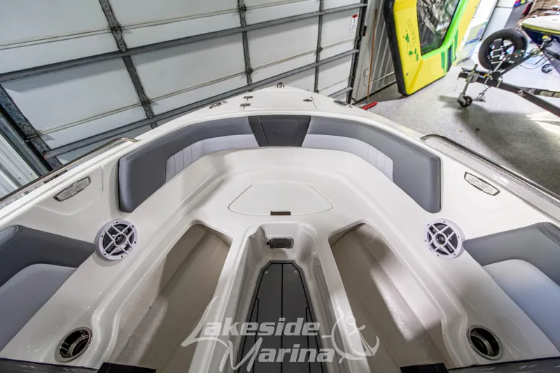 Slide: The Image of 2026 Chaparral 23 SSi boat interior with seating and speakers in a garage. - 27