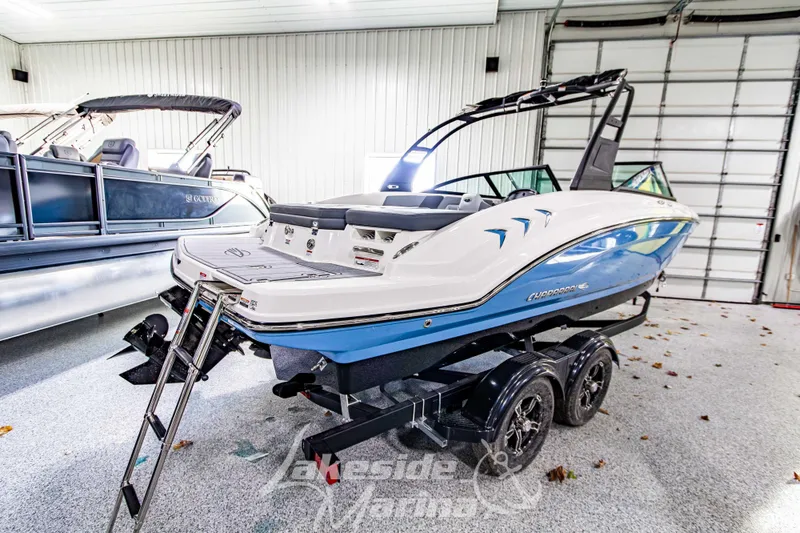 Slide: The Image of 2026 Chaparral 23 SSi boat in showroom, blue and white design, on trailer. - 3