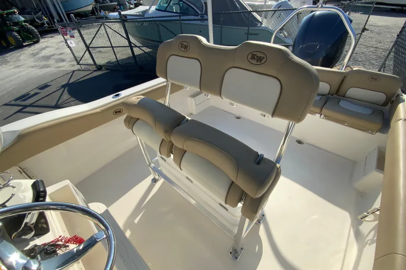 Slide: The Image of 2019 Key West 239 FS boat interior with beige seating and steering wheel. - 16