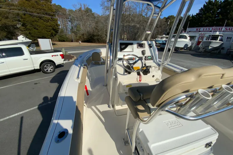Slide: The Image of 2019 Key West 239 FS boat interior with steering console and seating, parked outdoors. - 21