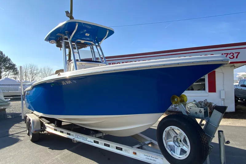 Slide: The Image of 2019 Key West 239 FS boat on trailer, vibrant blue hull, parked outdoors. - 3