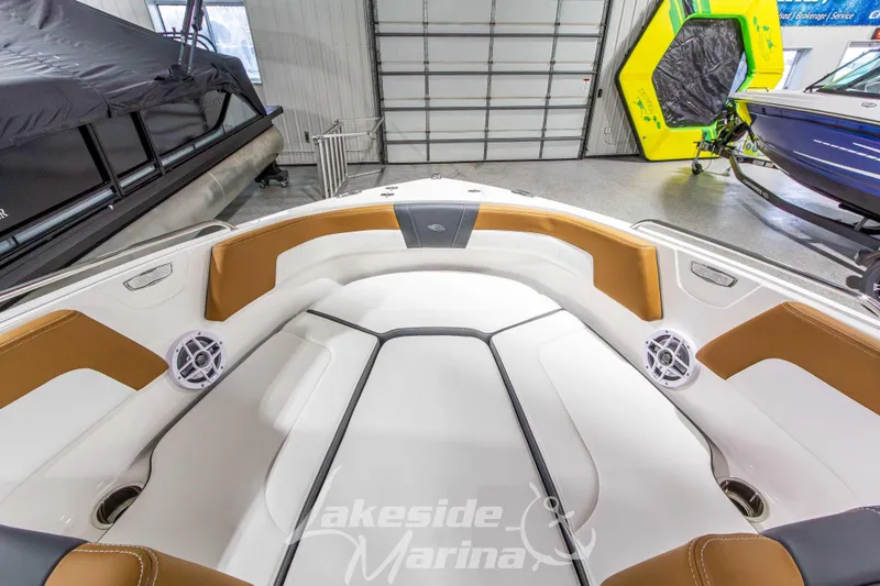 Slide: The Image of 2026 Chaparral 23 SSi boat interior with tan and white seating in showroom. - 28