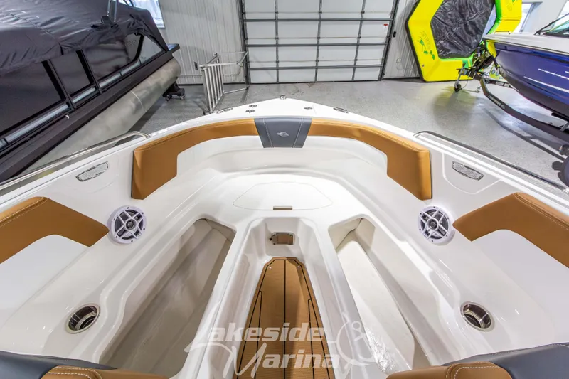 Slide: The Image of 2026 Chaparral 23 SSi boat interior with tan seating and speakers in a showroom. - 30