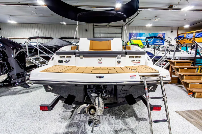 Slide: The Image of 2026 Chaparral 23 SSi boat in showroom, rear view with swim platform and ladder. - 5
