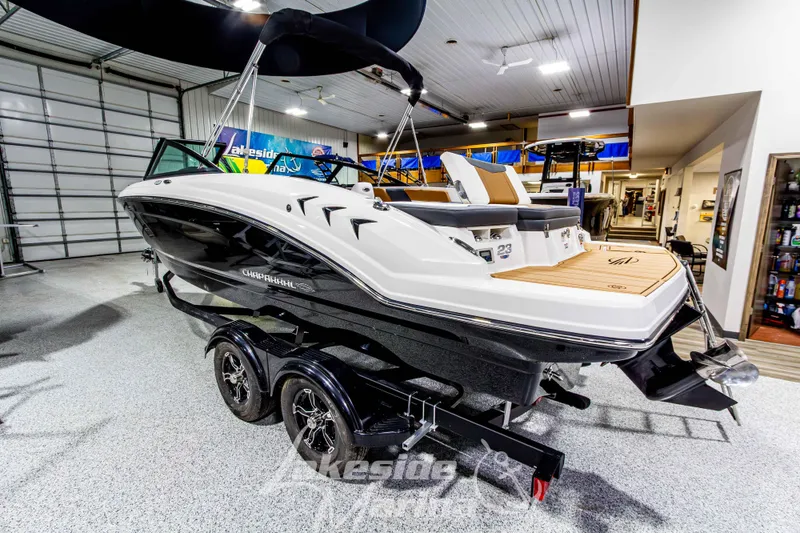 Slide: The Image of 2026 Chaparral 23 SSi boat on trailer in showroom, featuring sleek design and modern amenities. - 7