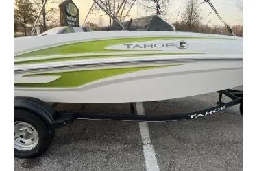 Slide: The Image of 2024 Tahoe T16 boat with green accents on a trailer in a parking lot. - 3