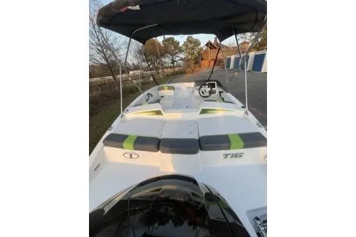 Slide: The Image of 2024 Tahoe T16 boat with canopy, docked near trees and storage units. - 4