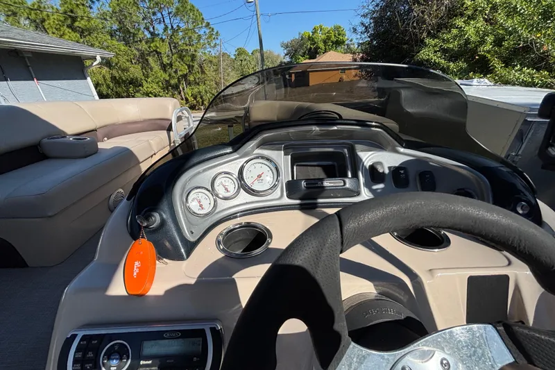 Slide: The Image of 2019 Sun Tracker Party Barge 20 DLX dashboard with gauges and steering wheel. - 21