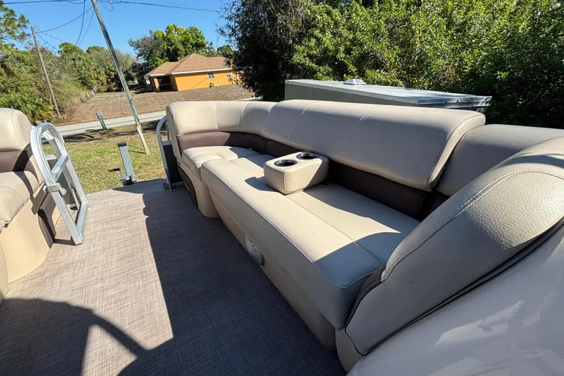 Slide: The Image of 2019 Sun Tracker Party Barge 20 DLX interior with beige seating and cup holders. - 32