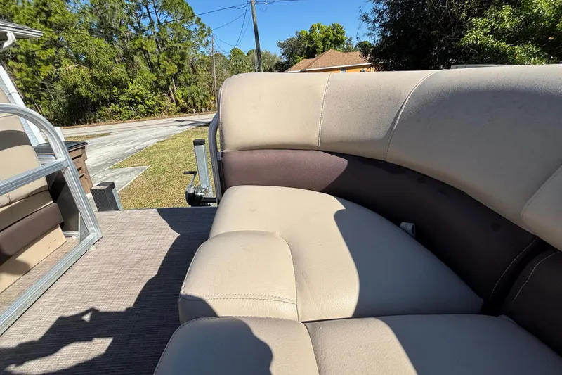 Slide: The Image of 2019 Sun Tracker Party Barge 20 DLX interior seating with beige upholstery, outdoor setting. - 35
