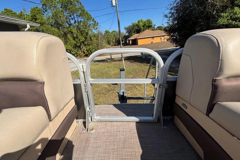 Slide: The Image of 2019 Sun Tracker Party Barge 20 DLX interior with beige seating and open gate. - 44