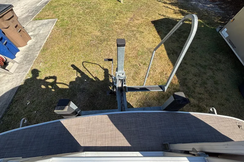 Slide: The Image of 2019 Sun Tracker Party Barge 20 DLX trailer hitch and ladder on grass. - 45