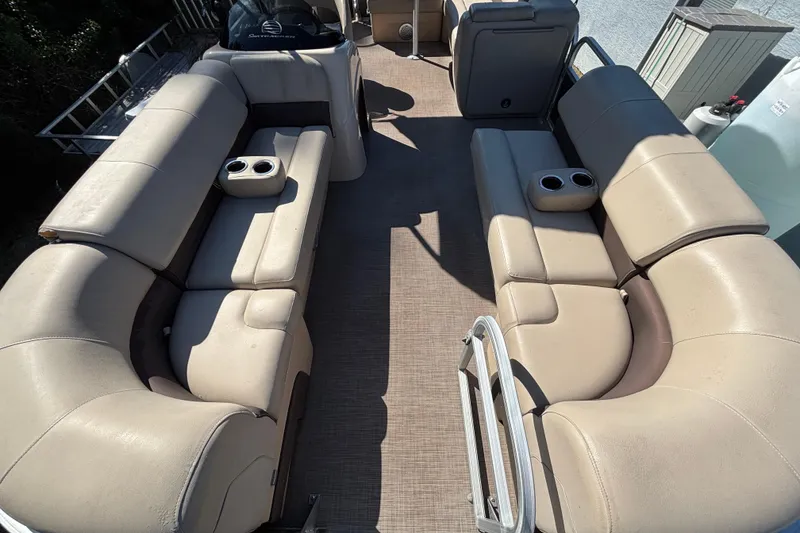 Slide: The Image of 2019 Sun Tracker Party Barge 20 DLX interior with beige seating and cup holders. - 46
