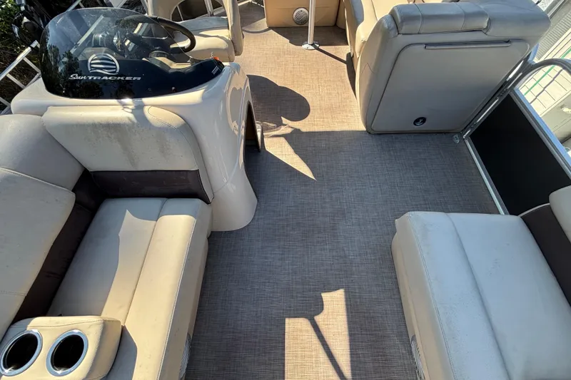 Slide: The Image of 2019 Sun Tracker Party Barge 20 DLX interior with beige seating and steering console. - 52