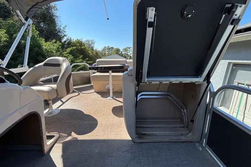 Slide: The Image of 2019 Sun Tracker Party Barge 20 DLX interior with seating and storage compartment. - 56