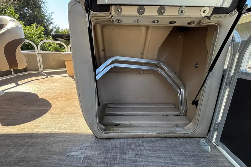 Slide: The Image of 2019 Sun Tracker Party Barge 20 DLX storage compartment with seating and railing visible. - 57