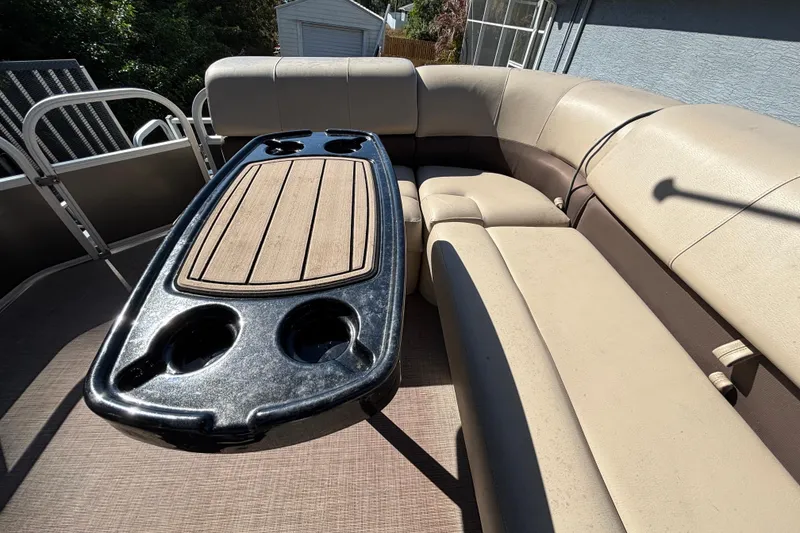 Slide: The Image of 2019 Sun Tracker Party Barge 20 DLX with spacious seating and table, under clear blue sky. - 63