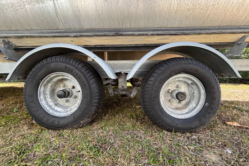 Slide: The Image of Trailer wheels of a 2019 Sun Tracker Party Barge 20 DLX on grass. - 76