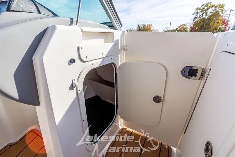 Slide: The Image of 2026 Chaparral 23 SSi boat interior with open storage compartment and wooden flooring. - 21