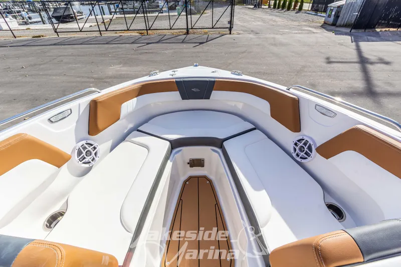 Slide: The Image of 2026 Chaparral 23 SSi boat interior with tan and white seating, docked at marina. - 23