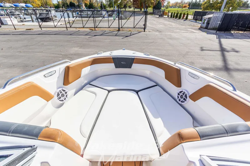 Slide: The Image of 2026 Chaparral 23 SSi boat interior with tan and white seating at marina. - 24