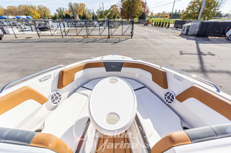 Slide: The Image of 2026 Chaparral 23 SSi boat interior with tan and white seating, dockside view. - 25
