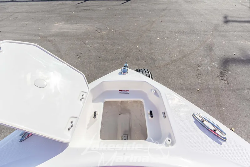 Slide: The Image of 2026 Chaparral 23 SSi boat bow storage compartment open on a sunny day. - 28
