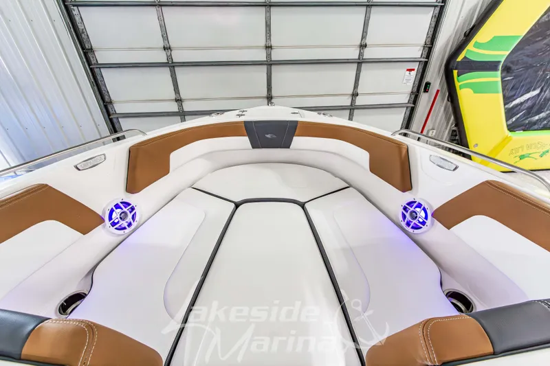 Slide: The Image of 2026 Chaparral 23 SSi boat interior with brown and white seating, blue LED speakers. - 29