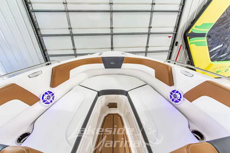 Slide: The Image of 2026 Chaparral 23 SSi boat interior with brown and white seating, blue LED speakers. - 30
