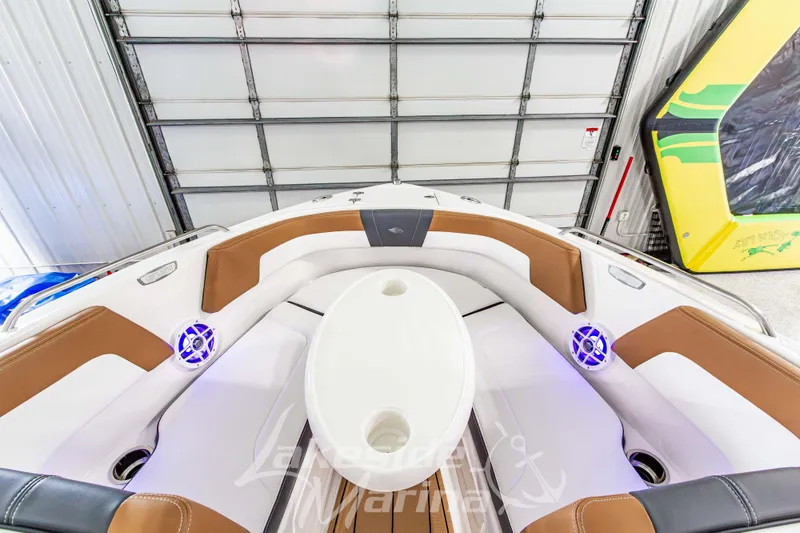 Slide: The Image of 2026 Chaparral 23 SSi boat interior with brown and white seating, blue LED speakers. - 31