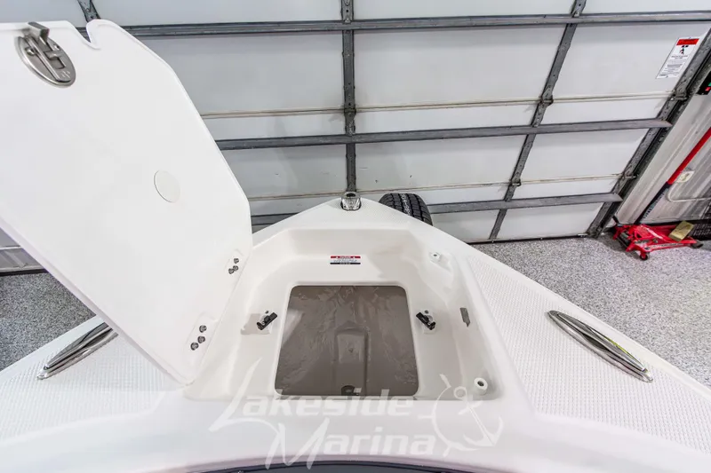 Slide: The Image of 2026 Chaparral 23 SSi boat storage compartment open in a garage setting. - 34